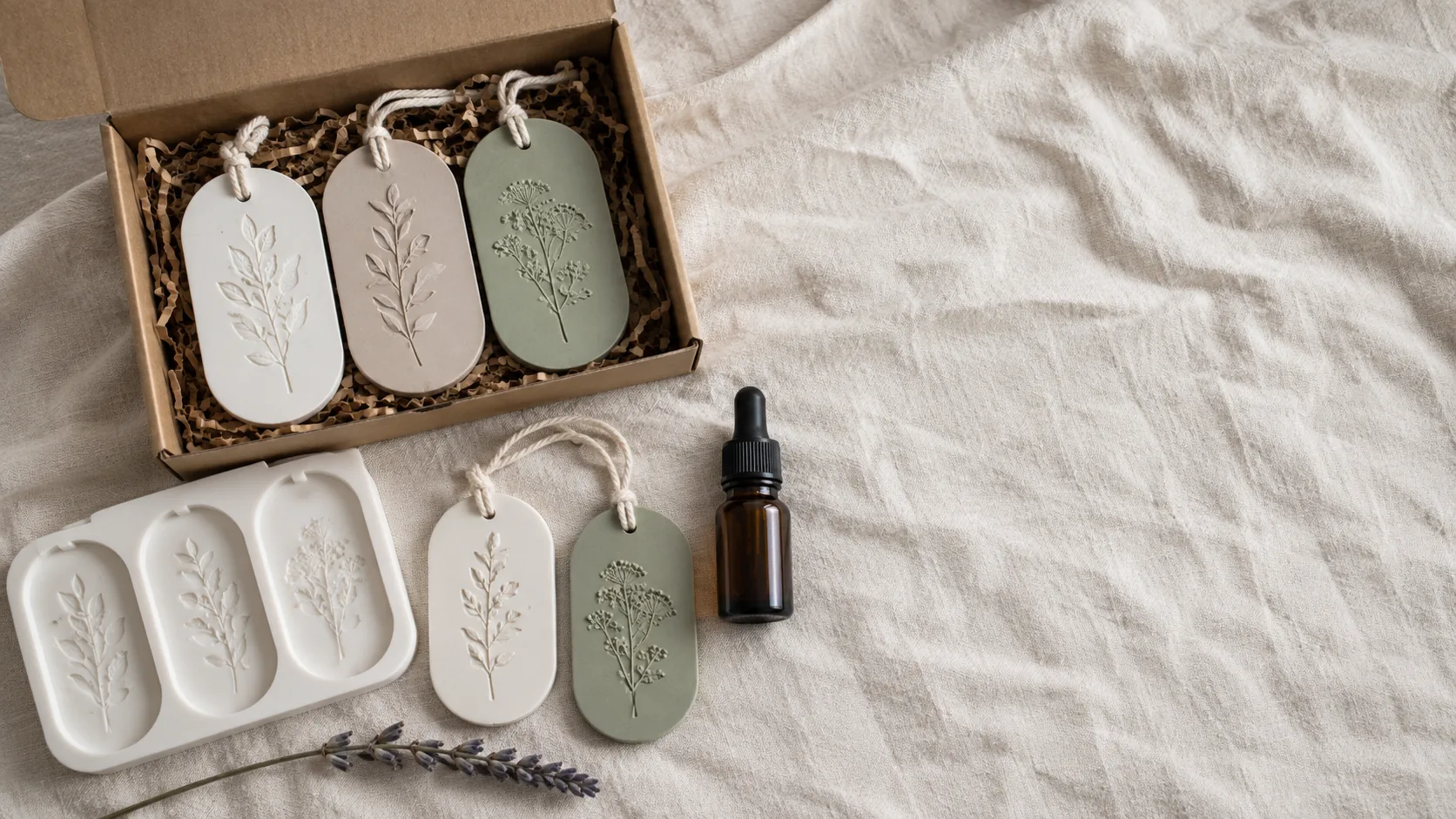 A boxed set of scented aroma stones beside the silicone mold, a bottle of fragrance oil and two hanging stones